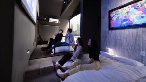 名古屋trive ozone - Vacation STAY 25323v的一群人坐在房间里的床边