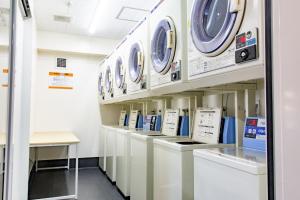 德岛Hotel Taiyonoen Tokushima Kenchomae - Vacation STAY 26351v的洗衣房里的一排洗衣机和烘干机