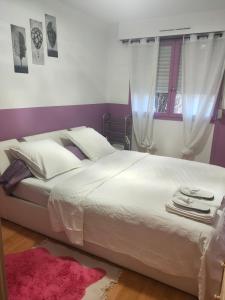 鲁昂Logement entier+ jardin privé et parking 2places的卧室配有一张白色大床和粉红色地毯