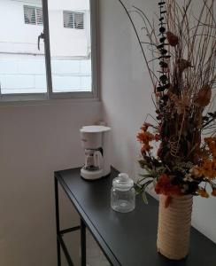 哈拉瓦科阿Apartamento Hogareño的一张桌子、咖啡壶和一个花瓶