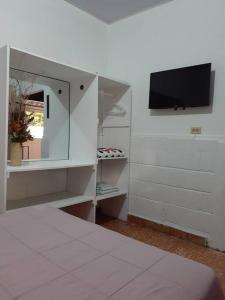 哈拉瓦科阿Apartamento Hogareño的一间卧室配有一张床,墙上配有电视