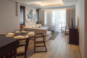卡马拉海滩The Pe La Resort, Phuket - SHA Extra Plus的客厅配有沙发和桌子
