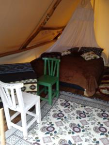 萨兰托glamping rustiko的一间卧室配有一张床、一把椅子和一张桌子