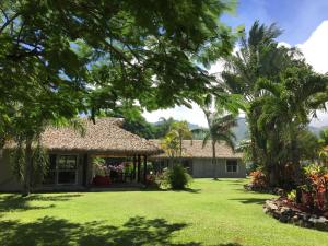 拉罗汤加布雷兹泻湖别墅酒店的一座棕榈树大院子的房子