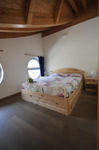 科马诺泰梅APPARTAMENTO MONTE - VALANDRO-的一间卧室配有一张木床和窗户