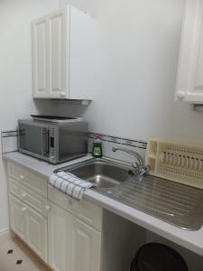 诺丁汉格罗夫旅馆的厨房配有水槽和微波炉