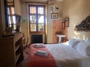 CéronLes Jardins des Soussilanges的一间卧室配有一张床,上面有两条毛巾