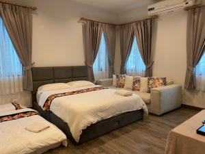 清迈Ban 5 Rai Pool Villa的一间卧室设有两张床、一张沙发和窗户。