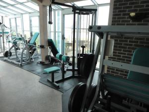 钦科蒂格岛屿度假汽车旅馆的健身房设有跑步机、椅子和砖墙
