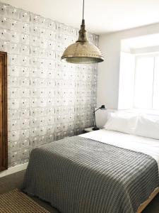 蒙蒂茹Charming Design House in Montijo, Casa 41的一间卧室配有一张大床和吊灯