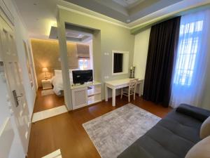 卡斯托里亚HOTEL TSARSI的客房设有床、电视和沙发。