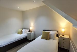 史宾桥East Lodge, Glenfintaig的配有两盏灯的小房间内的两张床