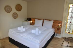 赞德沃特霍夫范玛斯酒店的卧室配有白色的床铺和白色的枕头