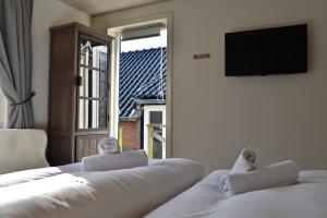 赞德沃特霍夫范玛斯酒店的配有2张白色床的客房设有电视和窗户。