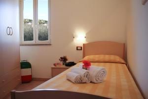 梵蒂冈角Hotel L'Ancora的一间卧室配有带毛巾的床