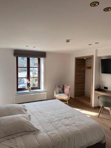 LaforêtBrasserie du Simonis的白色的卧室设有一张大床和一个窗户