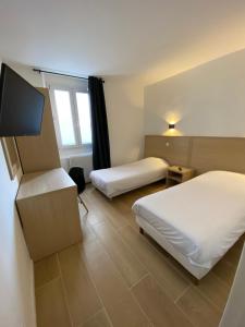 马赛Hôtel Raphael Prado的酒店客房设有两张床和一台平面电视。