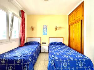 塔马达斯特Apartamento de 1 dormitorio en primera linea de mar, Tamaduste, El Hierro的一间卧室设有两张床和窗户。