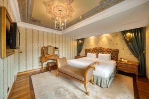 伊斯坦布尔Crowne Plaza Istanbul - Old City, an IHG Hotel的一间卧室配有一张床、一把椅子和一个吊灯。