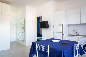 费拉约港Appartamento Miramare的厨房配有一张桌子,上面有蓝色的桌布