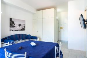 费拉约港Appartamento Miramare的一间带蓝色桌子和沙发的用餐室