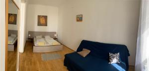 布尔诺Apartment with parking in the Center - 500m from Hlavní nádraží的客厅配有蓝色的沙发和镜子