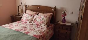 佩纳科瓦Casa da Tileira的一张带粉红色花卉图案的床铺和花瓶