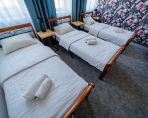 新苏尔Kelman Inn Global Nowa Sól的客房内的三张床和毛巾