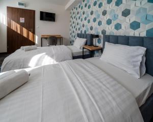 新苏尔Kelman Inn Global Nowa Sól的配有白色床单的酒店客房内的两张床