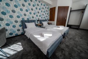 新苏尔Kelman Inn Global Nowa Sól的配有蓝色和灰色壁纸的客房内的两张床