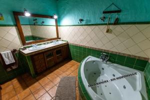 巴列埃尔莫索Casa Rural Abuelo Ramón的带浴缸、水槽和镜子的浴室