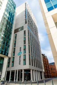 曼彻斯特Motel One Manchester-St. Peter´s Square的一座高大的白色建筑,上面有亚马逊标志