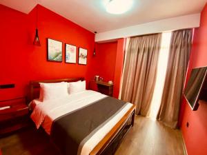 第比利斯Hotel Linge的红色的卧室设有床和窗户