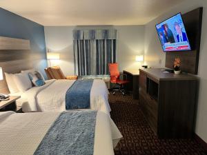 GarnettGarnett Hotel & RV Park的酒店客房设有两张床和一台平面电视。