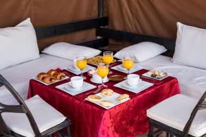 马拉喀什利亚德泰纳姆酒店的床上的桌子,上面摆放着食物和饮料