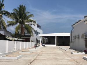 Vinh HoaThanh Tuan Motel的一座白色的建筑,前面有棕榈树