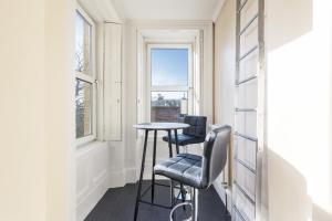 艾尔Beautiful 2 to 3 bed apartment with stunning views!的窗户客房内的小桌子和两把椅子