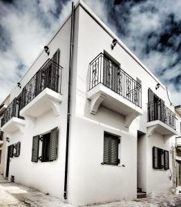 卡尔扎迈纳ANGONI SUITES的白色的建筑,旁边设有阳台