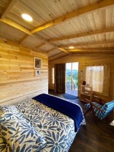 锡帕基拉Serás Libre Refugio的小木屋卧室配有1张床和1把椅子
