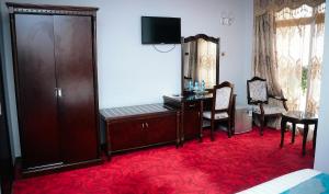 亚的斯亚贝巴Ras Amba Hotel的客房设有书桌、椅子和桌子。