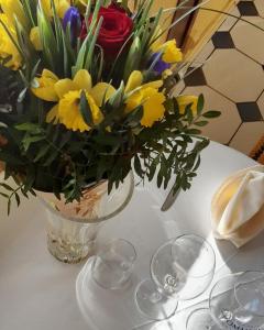 勒克罗图瓦Hôtel MADO的酒杯桌子上的花瓶