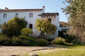 马尔旺Quinta da Saimeira的一座白色的房屋,有树木和院子