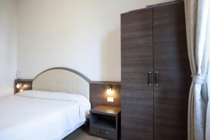 米兰阿马尔菲酒店 的卧室配有白色的床和木制橱柜。