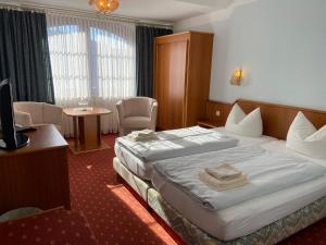 马兰迪Hotel Seerose Bad Malente的酒店客房设有一张大床和一张桌子。