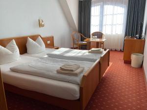 马兰迪Hotel Seerose Bad Malente的酒店客房,配有带毛巾的床