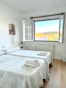 欧德鲁佐Pensión Maruja *的白色卧室设有两张床和大窗户