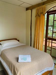 阿约拉港Nelyza's Suites & Adventure的一间卧室配有一张床,床上有毛巾