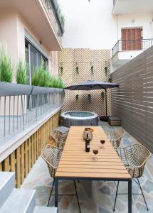 纳弗帕克托斯Lepanto Luxury Apartments GF的阳台的天井配有木桌和椅子