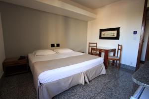 贝洛奥里藏特萨瓦西酒店的卧室配有一张床和一张桌子及椅子