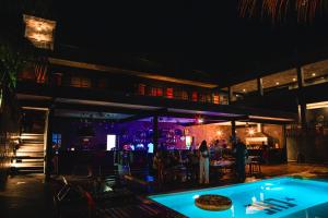 巴卡拉尔Che Bacalar Hostel & Bar Adults Only的享有酒吧和游泳池的夜景